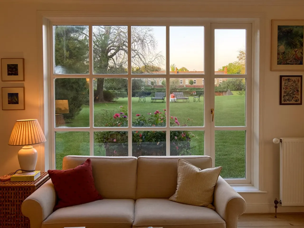 Warm living room with a large double-glazed window and soft lamps