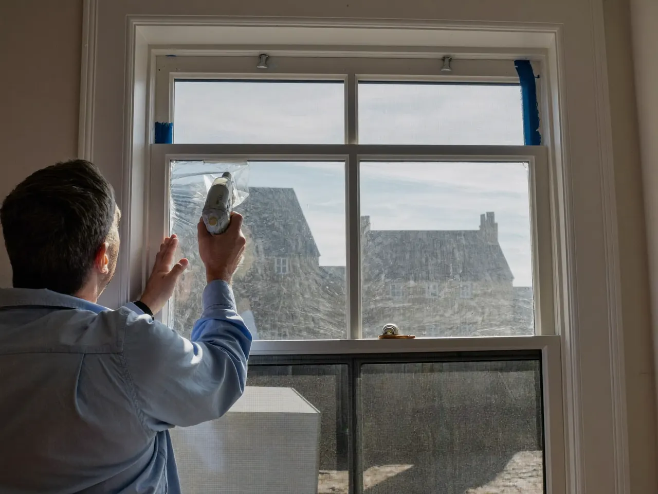 Installer fitting and sealing a new double-glazed window in a home